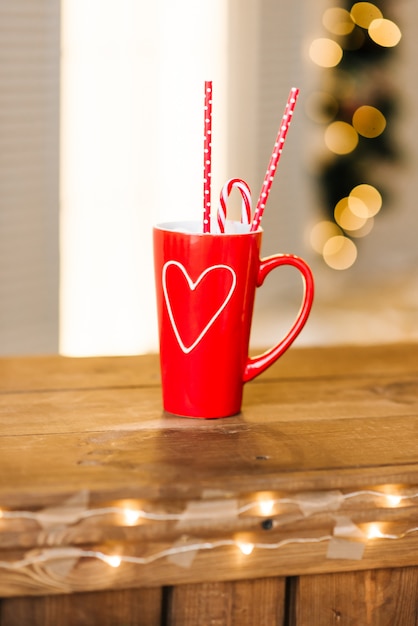 Taza roja con chocolate caliente en una mesa de madera