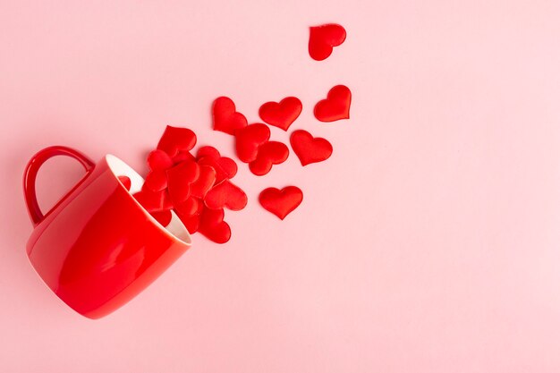 taza roja y corazones en rosa