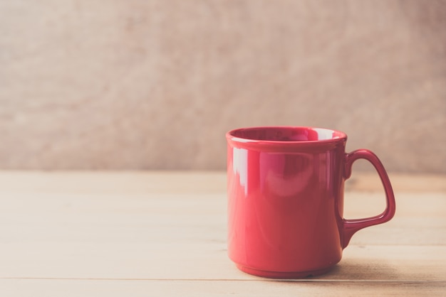 Foto taza roja en el fondo de la pared de madera