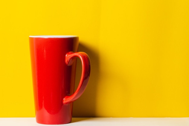 Taza roja sobre fondo amarillo