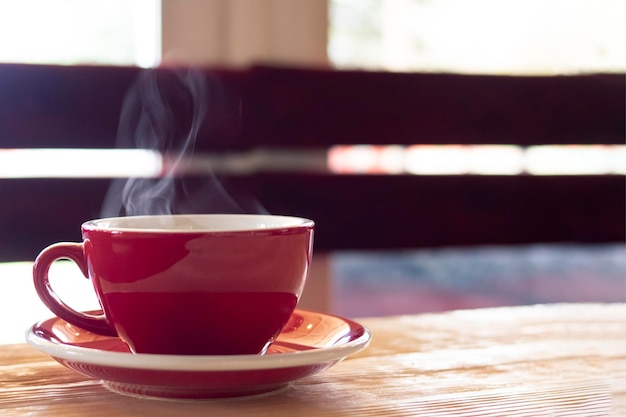 Taza roja con vapor sobre la mesa