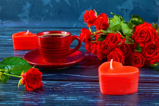 Taza roja de velas de café en forma de corazón un ramo de rosas rojas composición romántica