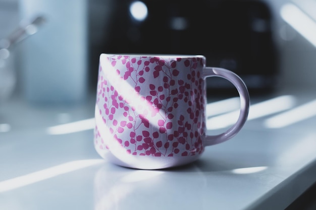 Taza rosa en la mesa de la cocina