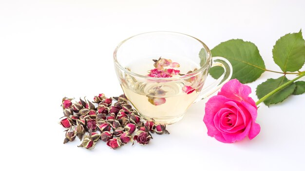 Una taza de rosa del té se levantó en un fondo blanco.