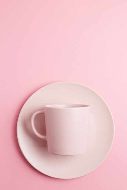 Taza rosa vacía sobre fondo rosa