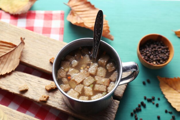 Una taza de sopa en una alfombra de madera