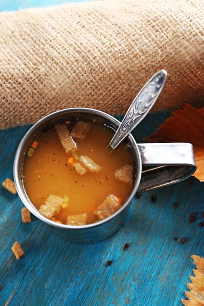 Foto taza de sopa y servilleta sobre fondo de madera azul