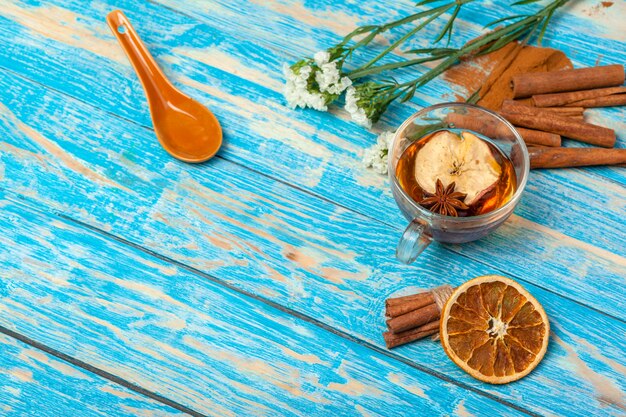 Taza con té aromático de canela caliente en mesa de madera