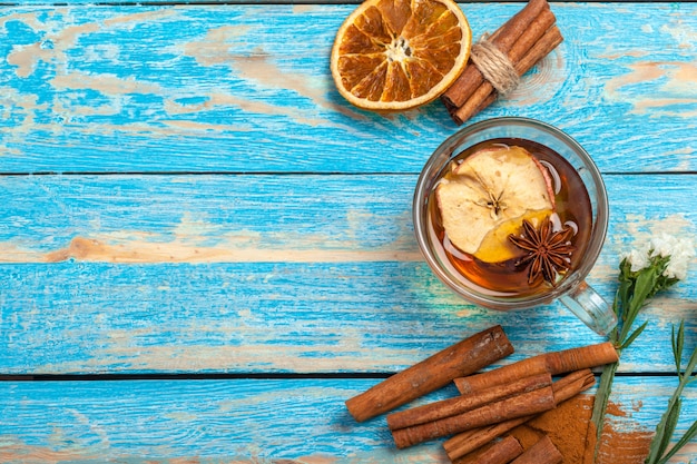 Taza con té aromático de canela caliente en mesa de madera