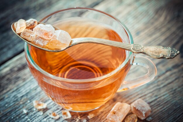 Taza de té y azúcar de caña caramelizada en cuchara