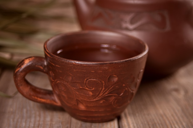 Taza de té y azúcar con tetera en el fondo