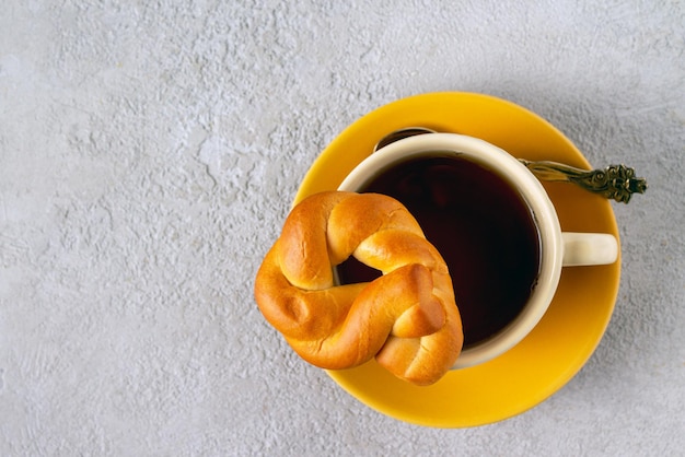 Una taza de té y un bagel en un espacio de copia de fondo beige