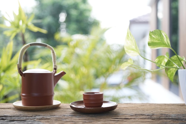 Taza de te de barro y taza de té en una mesa de madera