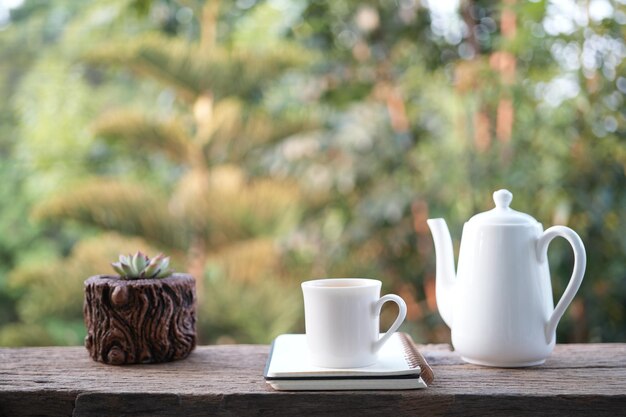 Foto taza de té blanca de cerámica y taza de té con una mini olla de cactus