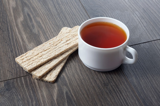 Taza de té blanco con galletas en una mesa de madera