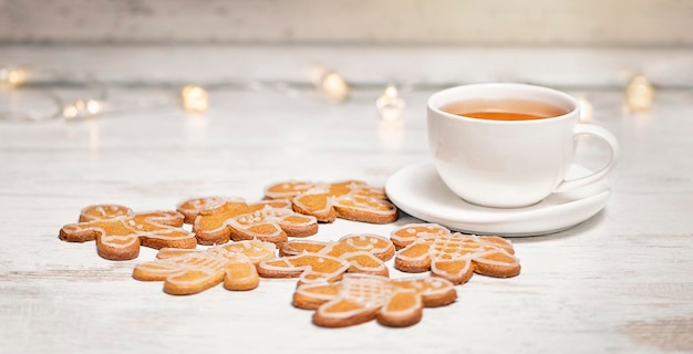 Una taza de té blanco con hombres de jengibre.