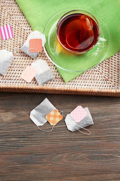 Foto taza de té con bolsitas de té en caja sobre fondo de mesa de madera