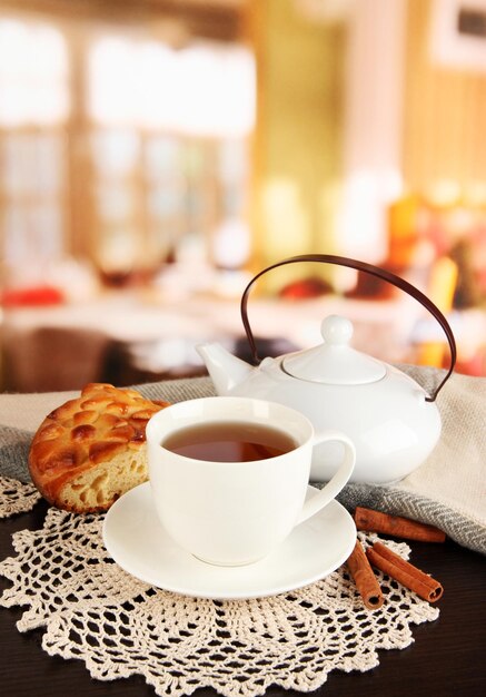 Taza de té con bufanda en la mesa en la habitación