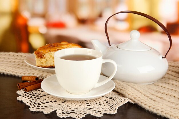 Taza de té con bufanda en la mesa en la habitación