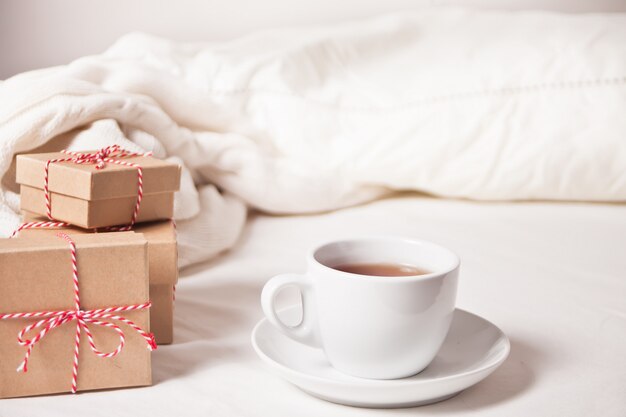 Taza de té, cajas de regalo de Navidad, cuadros de punto en el blanco