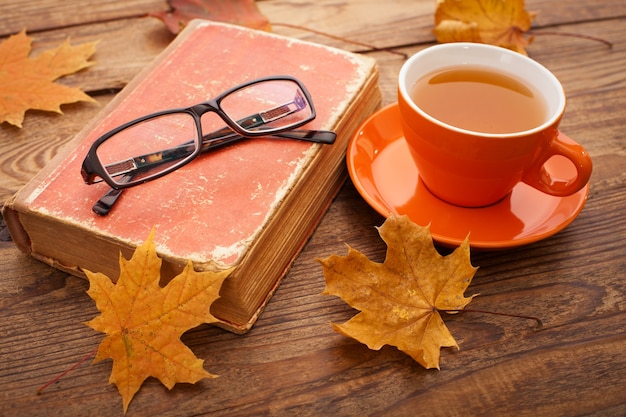 Taza de té caliente con hojas de otoño