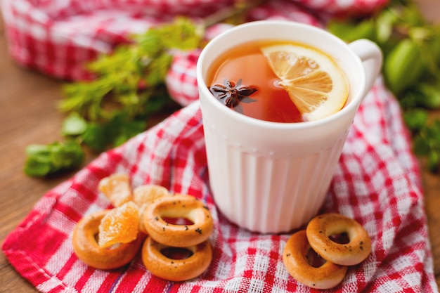 Taza de té caliente con limón y anís estrellado.