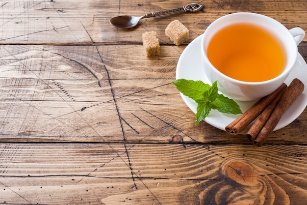 Taza de té caliente con menta y azúcar morena