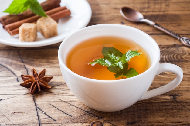 Taza de té caliente con menta y azúcar morena