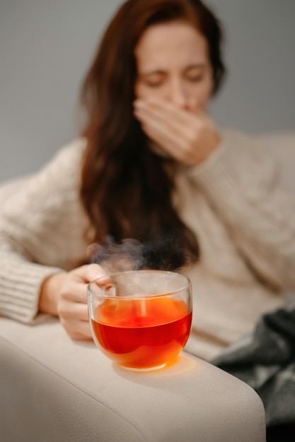 Foto una taza de té caliente para los resfriados y la gripe mantiene enferma a la mujer