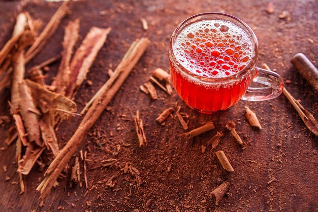 Taza de té de canela en una foto horizontal de fondo de madera