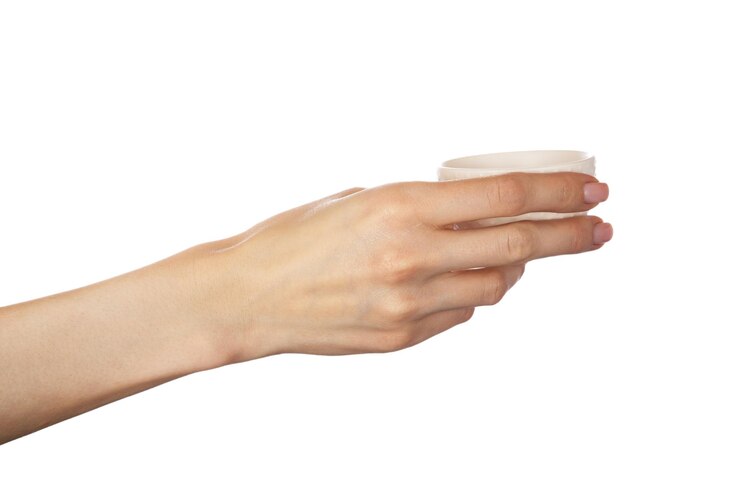 Foto taza de té de cerámica en mano femenina aislado sobre fondo blanco.