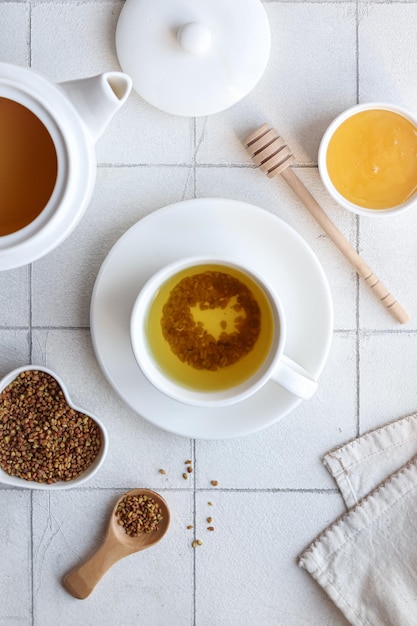 Una taza de té con una cuchara y miel encima.