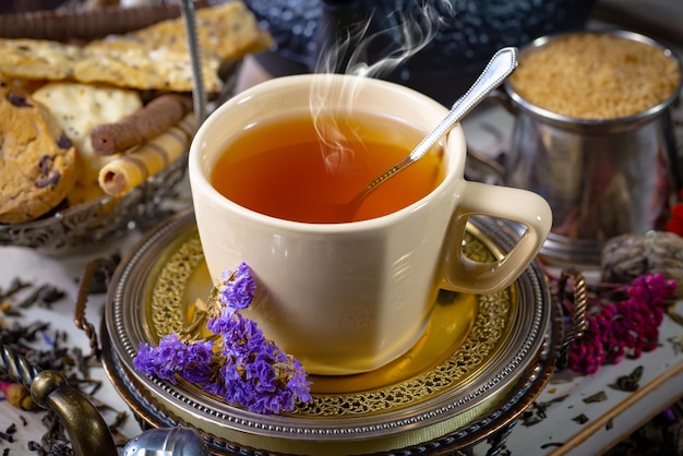 Foto una taza de té con una cuchara y un montón de pan sobre la mesa.