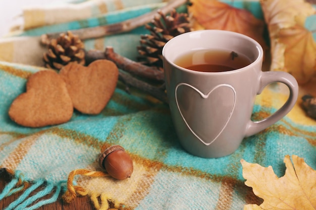 Taza de té con decoración de otoño en mesa de madera