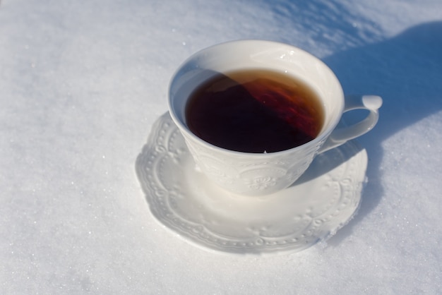 Taza de té para el desayuno sobre fondo de nieve fuera