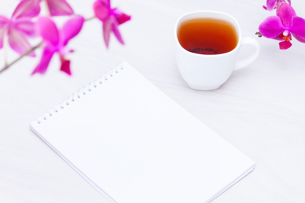 Taza de té, flores, cuaderno de papel. Redacción, concepto independiente.