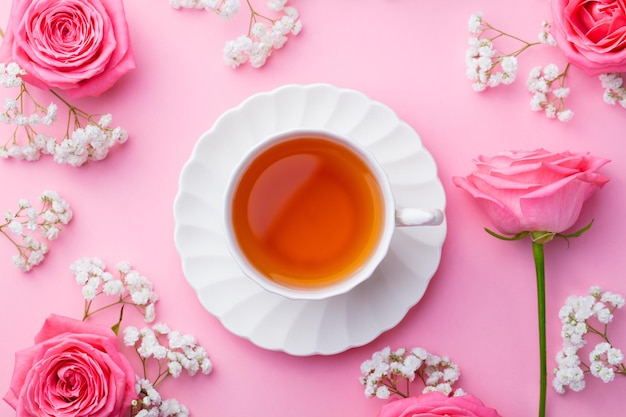 Foto taza de té con flores frescas sobre fondo rosa