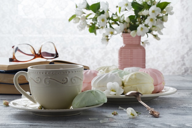 Taza de té con flores de primavera flor de cerezo y libro antiguo en una pared de madera