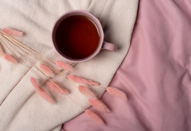 Una taza de té y flores secas en una cama Espacio de vista superior para texto Concepto romántico