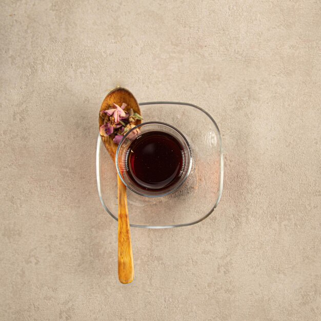 Una taza de té con flores secas sobre un fondo crema.