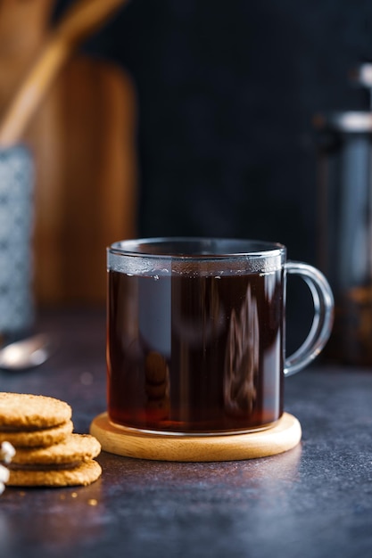 Una taza de té con una galleta sobre la mesa