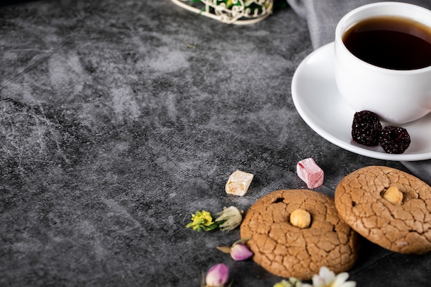 Una taza de té con galletas de almendras en el mármol