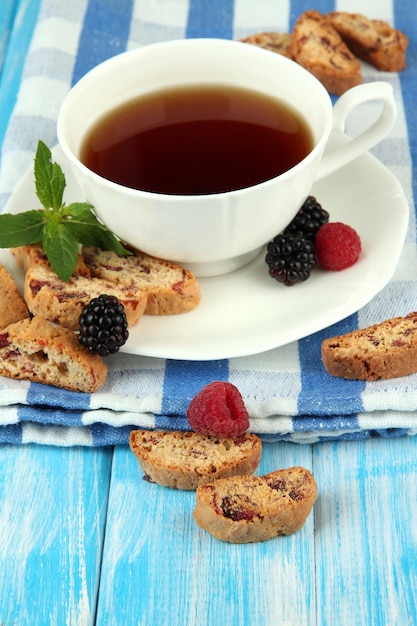 Taza de té con galletas y bayas en primer plano de la mesa