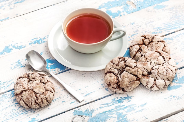 Taza de té con galletas en la mesa antigua