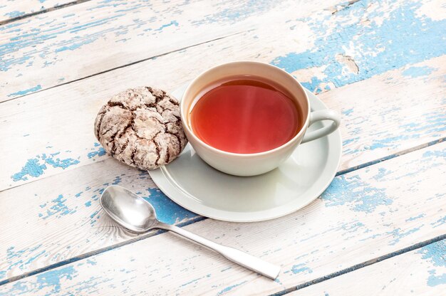 Taza de té con galletas en la mesa antigua.