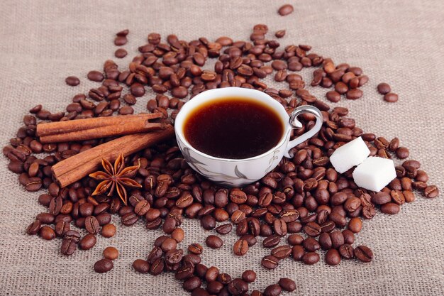 Una taza de té y galletas y naranja sobre la mesa de madera.