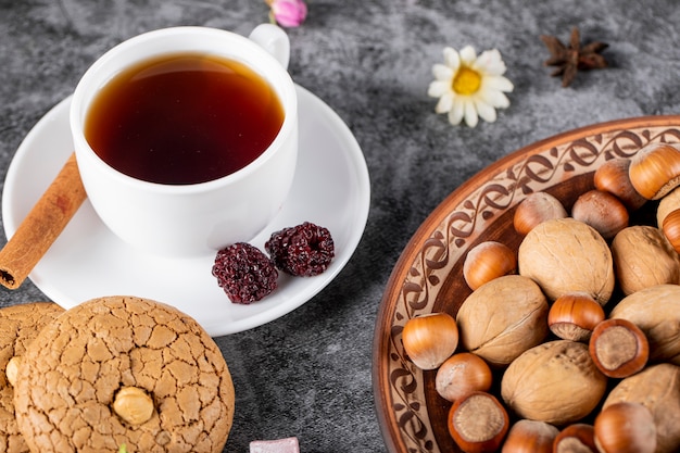 Una taza de té con galletas y nueces. vista superior