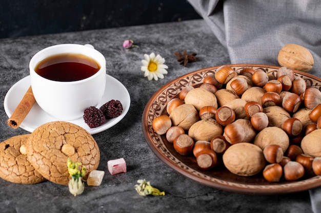 Una taza de té con galletas y nueces.