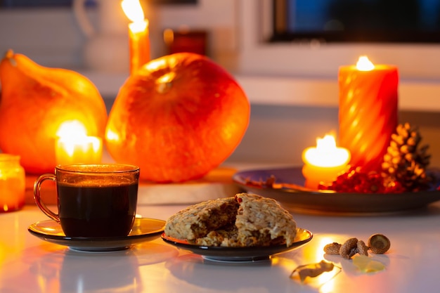 taza de té con galletas y velas encendidas