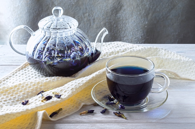 Taza de té de guisantes Mariposa (flores de guisante, guisantes azules) para bajar de peso, desintoxicarse en una mesa de madera gris